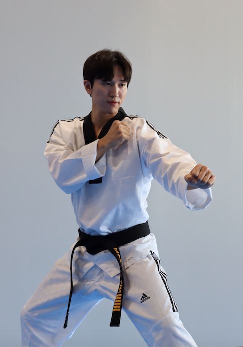 Master Min in a black belt uniform in a fighting stance